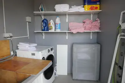 a laundry room with a washing machine and towels at Mill House in Ponta do Sol