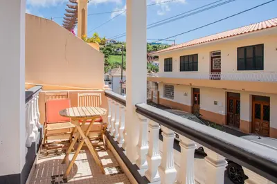 a balcony with a table and chairs on a building at Mill House in Ponta do Sol