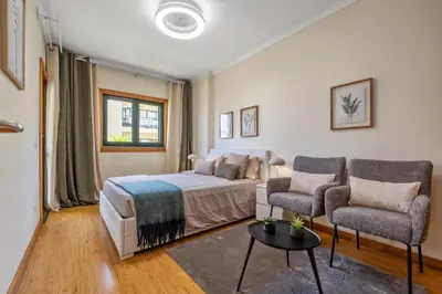 a bedroom with a bed and two chairs at SUPER Anadia - Vintage in Funchal