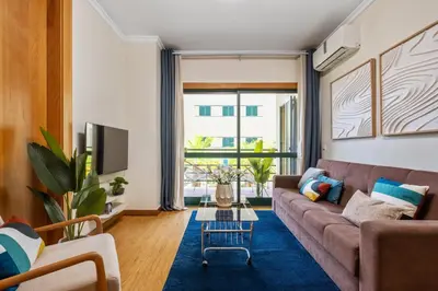 a living room with a brown couch and a blue rug at SUPER Anadia - Vintage in Funchal