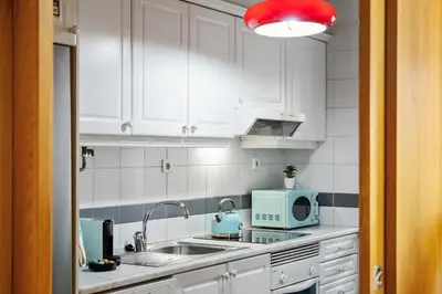 a kitchen with white cabinets and a sink and a microwave at SUPER Anadia - Vintage in Funchal