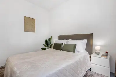 a bedroom with a white bed with two green pillows at SUPER Zen in Ponta Delgada