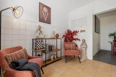 a living room with two chairs and a book shelf at SUPER Zen in Ponta Delgada