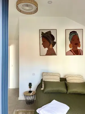 a bedroom with a bed and three pictures on the wall at Casa Happy in Funchal