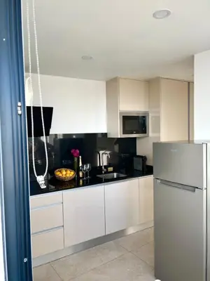 a kitchen with white cabinets and a silver refrigerator at Casa Happy in Funchal