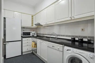 a white kitchen with a sink and a dishwasher at Doca's Refuge by Homie in Funchal