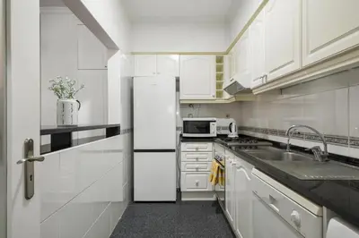 a white kitchen with a refrigerator and a sink at Doca's Refuge by Homie in Funchal
