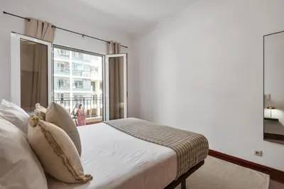 a bedroom with a bed and a large window at Doca's Refuge by Homie in Funchal