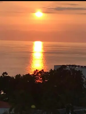 a sunset over the ocean with the sun in the sky at Garajau Madeira Holidays in Caniço
