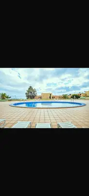 a picture of a swimming pool with two white chairs at Garajau Madeira Holidays in Caniço