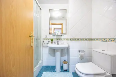 a white bathroom with a toilet and a sink at Garajau Madeira Holidays in Caniço