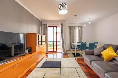 a living room with a couch and a television at Garajau Madeira Holidays in Caniço