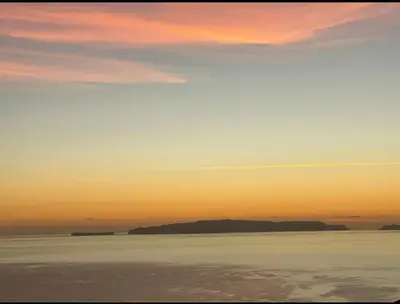 a sunset over the water with an island in the distance at Garajau Madeira Holidays in Caniço