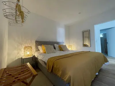a bedroom with a bed with two lamps and a bench at Maresia Gardens in Porto da Cruz