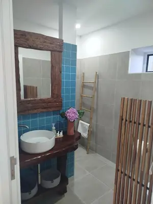 a bathroom with a sink and a mirror at Maresia Gardens in Porto da Cruz