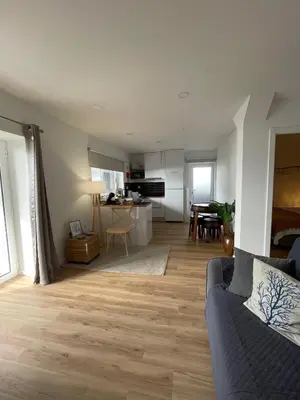 a living room with a couch and a kitchen at Maresia Gardens in Porto da Cruz
