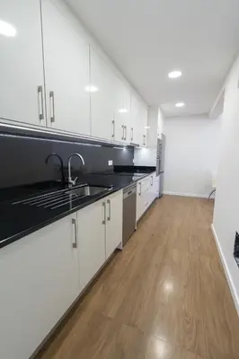 a kitchen with white cabinets and black counter tops at Casa do Moinho by Mill Escapes in Funchal