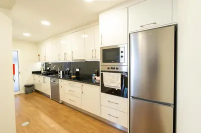 a kitchen with white cabinets and a stainless steel refrigerator at Casa do Moinho by Mill Escapes in Funchal