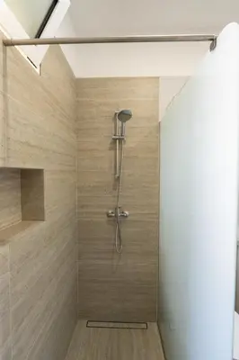 a shower in a bathroom with wooden walls at Casa do Moinho by Mill Escapes in Funchal