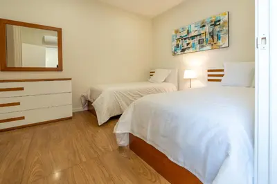 a bedroom with two beds and a dresser and a mirror at Casa do Moinho by Mill Escapes in Funchal