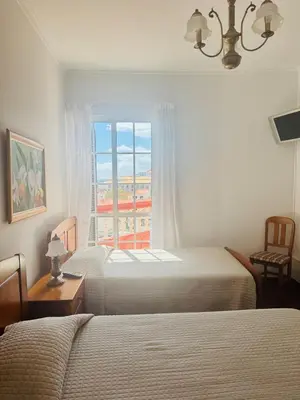a bedroom with two beds and a window at Casa da Rochinha in Santa Cruz