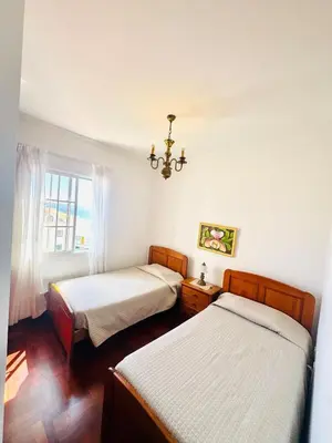 two beds in a room with a window at Casa da Rochinha in Santa Cruz