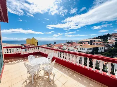 a balcony with a table and chairs and a view at Casa da Rochinha in Santa Cruz