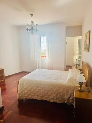 a bedroom with a large bed and a window at Casa da Rochinha in Santa Cruz