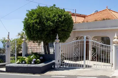 a gate in front of a house with a tree at Atlantic Flow House by Escape to Madeira in Arco da Calheta