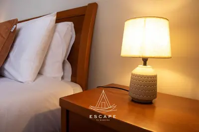 a lamp on a table next to a bed at Atlantic Flow House by Escape to Madeira in Arco da Calheta