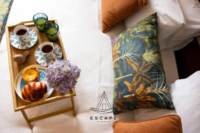 a tray of food and coffee and flowers on a bed at Atlantic Flow House by Escape to Madeira in Arco da Calheta