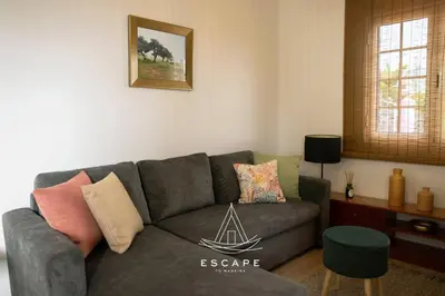 a living room with a gray couch and a table at Atlantic Flow House by Escape to Madeira in Arco da Calheta