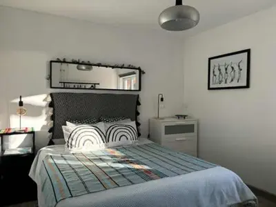a bedroom with a bed and a mirror on the wall at CasaDaMeiaLuaArrifana in Aljezur