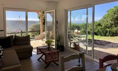 a living room with a couch and a view of the ocean at CasaDaMeiaLuaArrifana in Aljezur