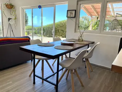 a dining room table and chairs in a living room at CasaDaMeiaLuaArrifana in Aljezur