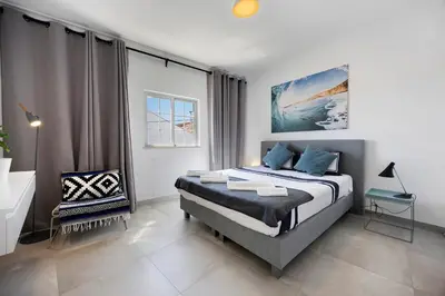 a bedroom with a king sized bed and a window at Casa Surfer’s Sanctuary - Algarve in Vila do Bispo