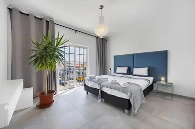 a bedroom with a large bed and a potted plant at Casa Surfer’s Sanctuary - Algarve in Vila do Bispo