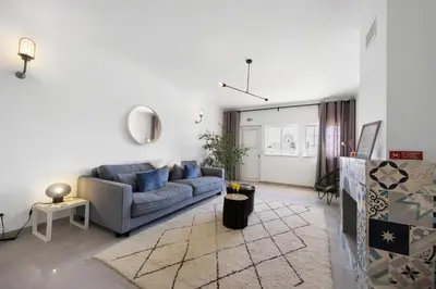 a living room with a blue couch and a rug at Casa Surfer’s Sanctuary - Algarve in Vila do Bispo