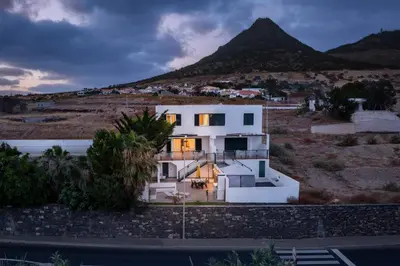 a house in front of a mountain at Casa Encosta do Sol by An Island Apart in Porto Santo