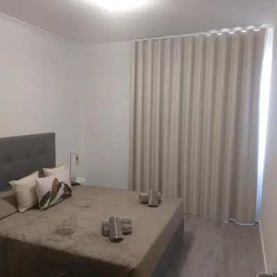 a bedroom with a large bed and a curtain at Atlantic View Free Parking in Funchal