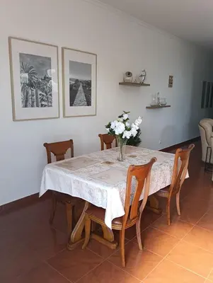 a dining room table with a vase of flowers on it at my flower in Ponta do Sol