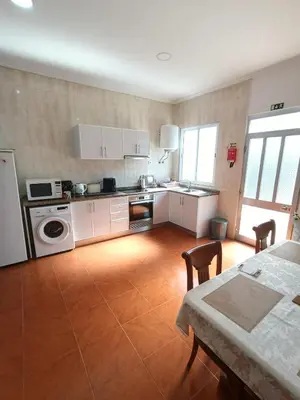 a large kitchen with white cabinets and a table and a tableablish at my flower in Ponta do Sol
