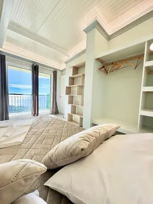 a bedroom with a large bed with a view of the ocean at Hera House, Ponta do Sol, Portugal in Canhas