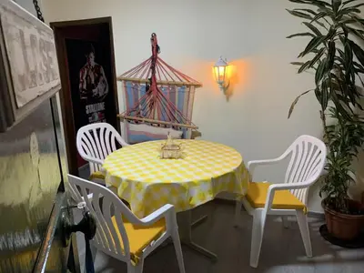 a table and chairs with a yellow and white table cloth at Casadarvore in Ponta Delgada