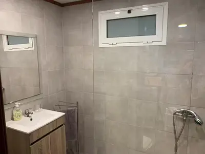 a bathroom with a sink and a tv on the wall at Casadarvore in Ponta Delgada