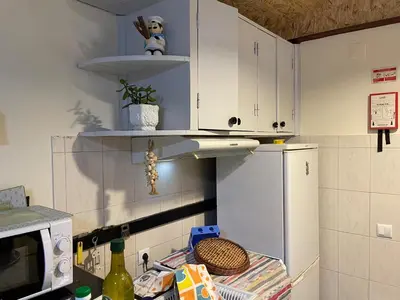 a kitchen with white cabinets and a white refrigerator at Casadarvore in Ponta Delgada