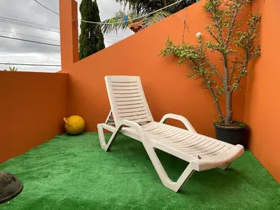 a white rocking chair sitting on a green lawn at Casadarvore in Ponta Delgada
