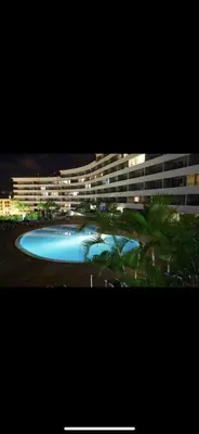 a large building with a blue pool in front of it at Forum Palace Madeira in Funchal