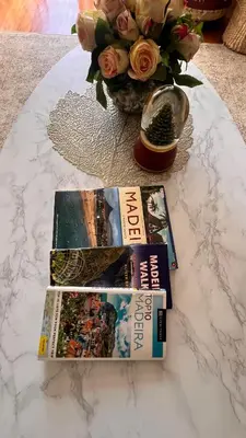 two books on a table next to a vase of flowers at Forum Palace Madeira in Funchal