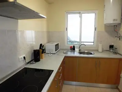 a kitchen with a sink and a microwave in it at Cozy Private Apartment Calheta in Arco da Calheta